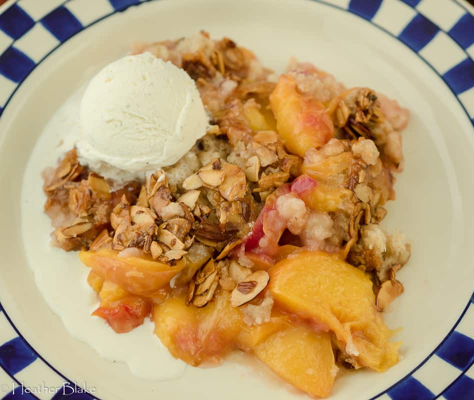 A picture of Peach Cobbler with Candied Almonds with a scoop of ice cream