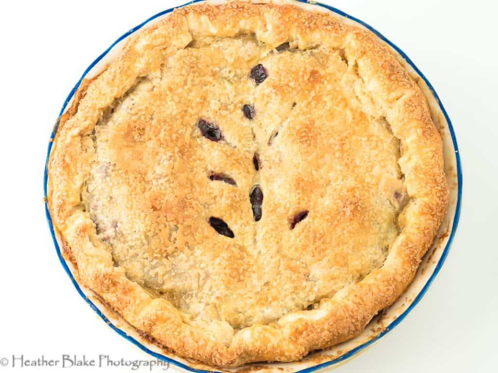 A picture of a warm blueberry pie straight from the oven.