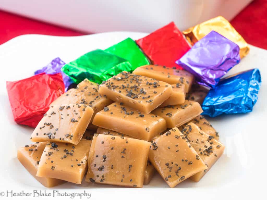 A picture of black sea salt caramels sliced and ready to wrapped in colorful tinfoil.