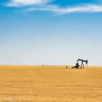 A picture of an oil pump in the middle of a Kansas wheat field.