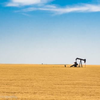 A picture of an oil pump in the middle of a Kansas wheat field.